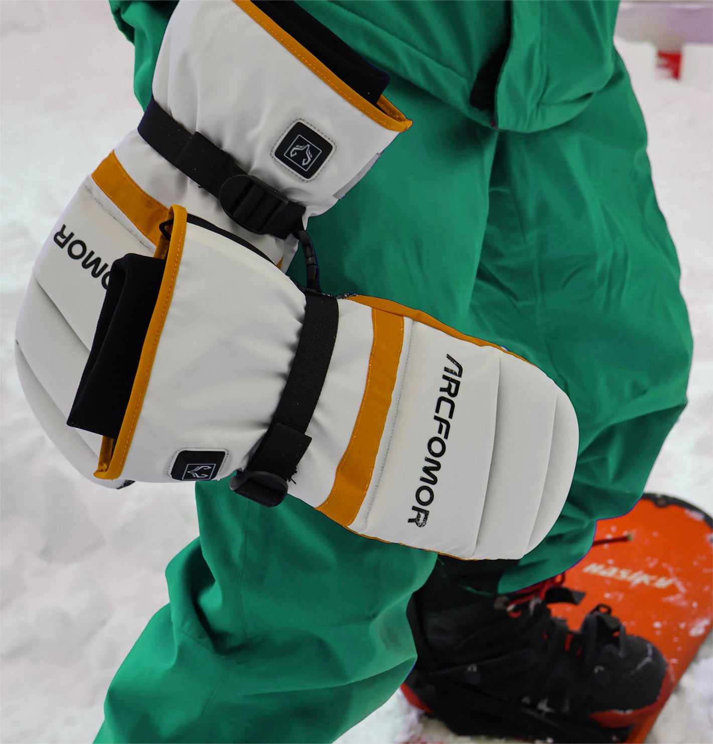 A snowboarding man happily playing in the snow wearing Toboggan heated gloves