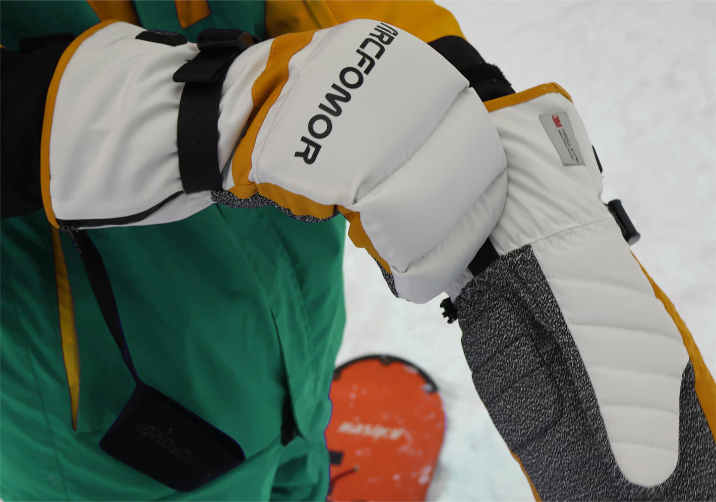 A snowboarding man happily playing in the snow wearing Toboggan heated gloves