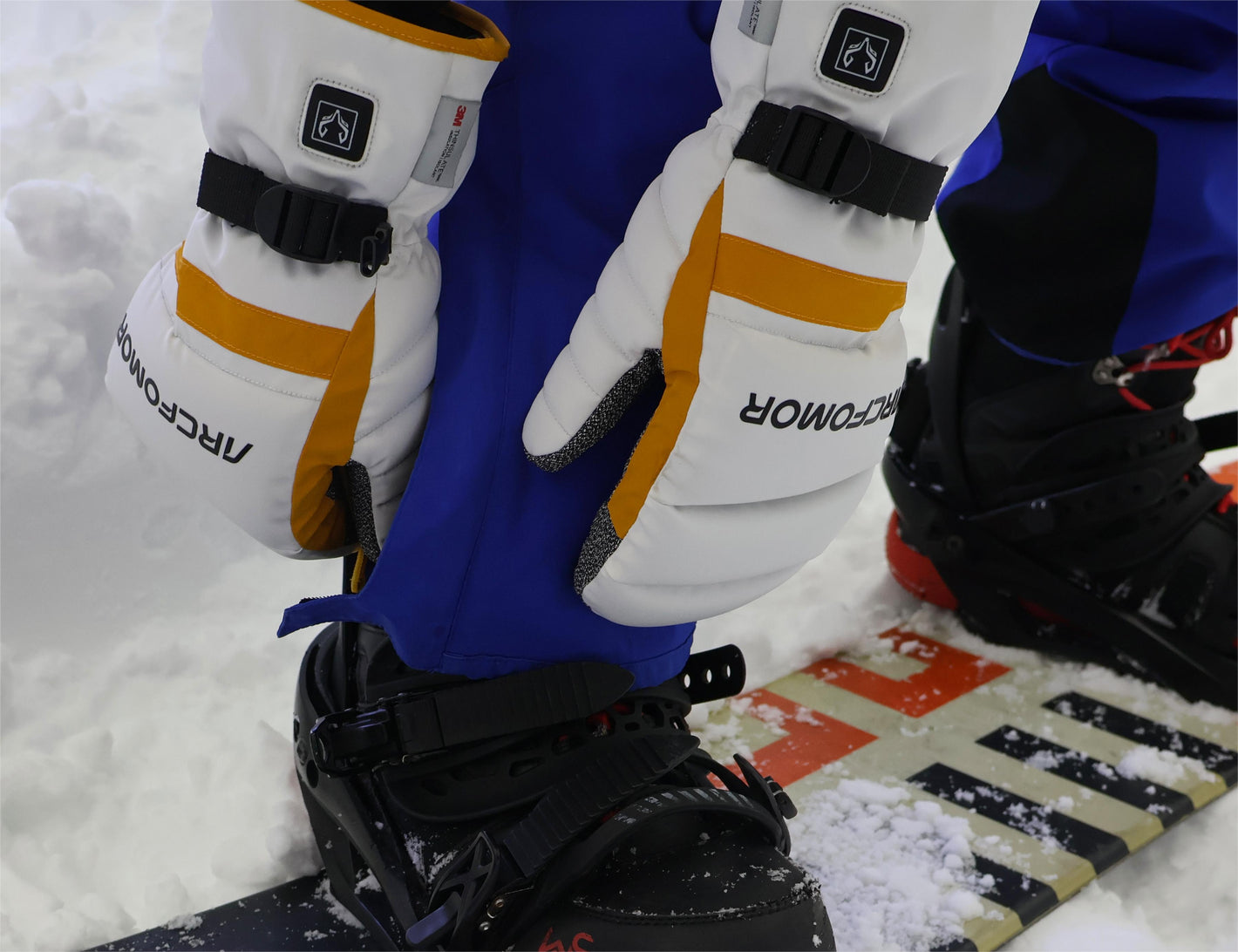 A snowboarding man happily playing in the snow wearing Toboggan heated gloves