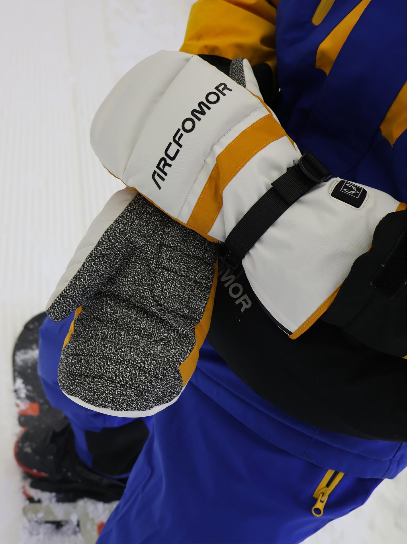 A snowboarding man happily playing in the snow wearing Toboggan heated gloves