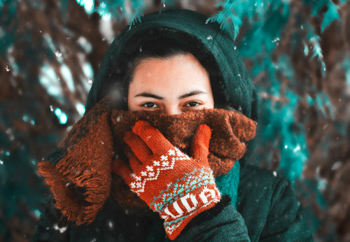 A woman in cold winter weather, wearing Arcfomor heated gloves, relishing the warmth and comfort they provide.