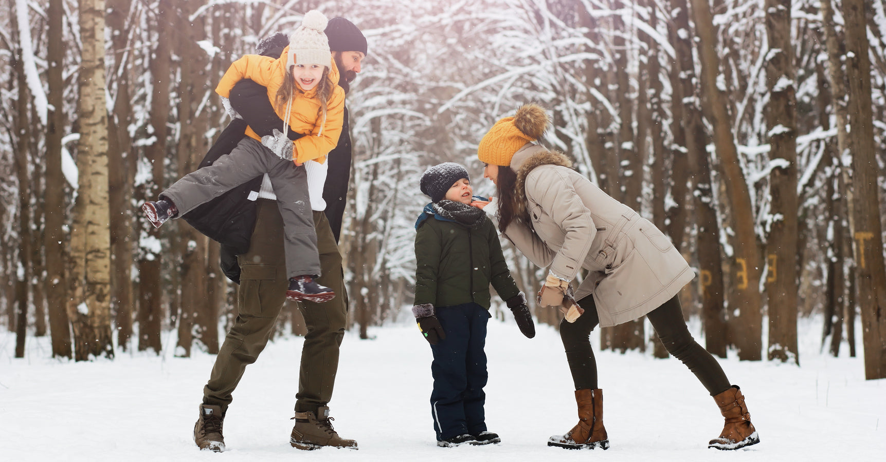 This image shows a happy young family having fun wearing Arcfomor gloves outdoors in the snow